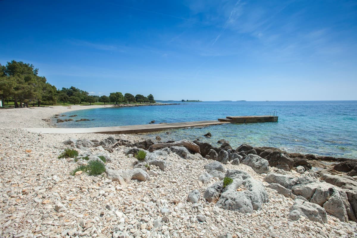 Cuvi Beach in Rovinj with families enjoying calm, shallow waters