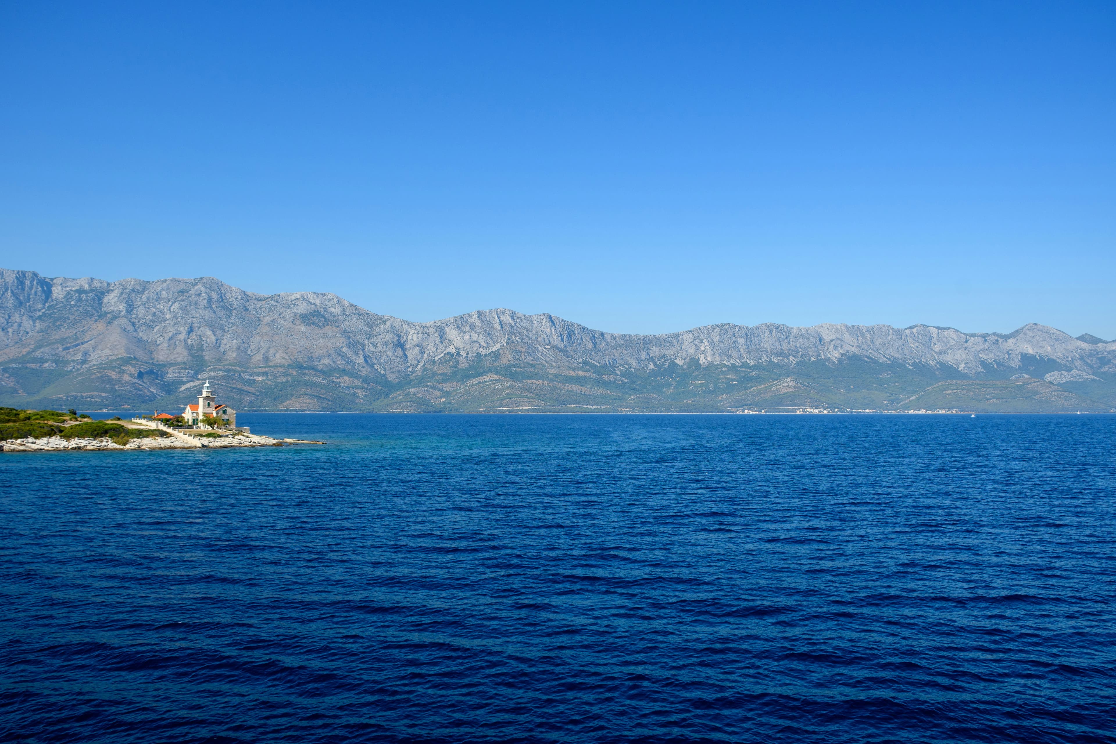 Croatian Adriatic coastline with a working lighthouse on a distant cape.